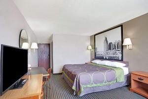 a hotel room with a bed and a flat screen tv at Super 8 by Wyndham Nashville/ Dntn/ Opryland Area in Nashville