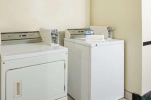 a laundry room with two washers and a dryer at Super 8 by Wyndham New Castle in New Castle