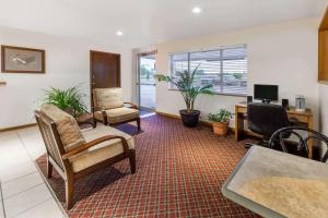 a living room with two chairs and a desk at Super 8 by Wyndham Ionia MI in Ionia