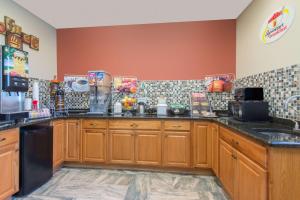 a kitchen with wooden cabinets and a counter top at Super 8 by Wyndham Youngstown/Austintown in Youngstown