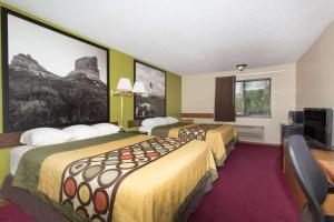 ein Hotelzimmer mit 2 Betten und einem Flachbild-TV in der Unterkunft Super 8 by Wyndham Chadron NE in Chadron