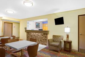 um quarto com uma mesa e cadeiras e uma lareira em Super 8 by Wyndham Lewisburg em Lewisburg