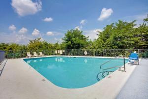 a swimming pool with a fence and a blue chair at Super 8 by Wyndham Nashville/ Dntn/ Opryland Area in Nashville +6 photos