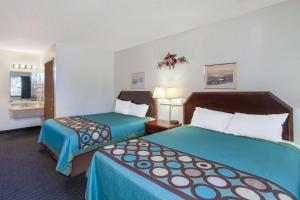 a hotel room with two beds with blue sheets at Super 8 by Wyndham Selma/Fresno Area in Selma