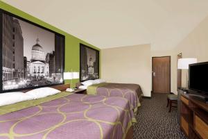 a hotel room with two beds and a flat screen tv at Super 8 by Wyndham Muncie/Ball St. College Area in Muncie +9 photos