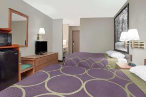a hotel room with two beds and a television at Super 8 by Wyndham Evansville East in Evansville