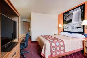 a hotel room with a bed and a flat screen tv at Hillside Inn & Suite in Martinsburg