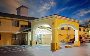 een geel gebouw met een boog op een parkeerplaats bij Super 8 by Wyndham Muncie/Ball St. College Area in Muncie