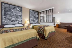 a hotel room with two beds and a couch at Super 8 by Wyndham Summersville in Summersville