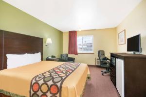 a hotel room with a bed and a flat screen tv at Super 8 by Wyndham Moriarty in Moriarty