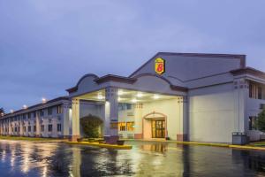 a building on a wet street in a parking lot at Super 8 by Wyndham Hartford in Hartford