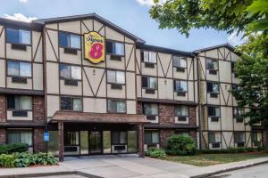 an apartment building with a hotel sign on it at Super 8 by Wyndham Groton in Groton