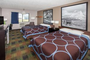 a hotel room with two beds and a flat screen tv at Super 8 by Wyndham Keokuk in Keokuk