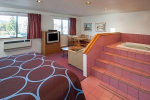 a hotel room with a tub and a bedroom at Super 8 by Wyndham Salmon Arm in Salmon Arm