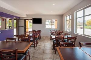 a restaurant with tables and chairs and a tv at Super 8 by Wyndham Salmon Arm in Salmon Arm