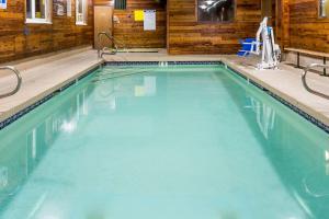 a swimming pool with blue water in a building at Super 8 by Wyndham Rock Springs in Rock Springs