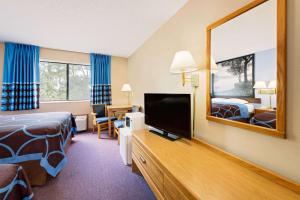 Habitación de hotel con cama y espejo en Super 8 by Wyndham Chariton, en Chariton