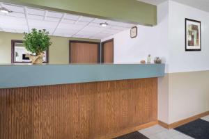 an office lobby with a counter and a potted plant at Super 8 by Wyndham Fond Du Lac in Fond du Lac