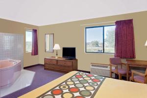 a living room filled with furniture and a tv at Super 8 by Wyndham Dyersville in Dyersville