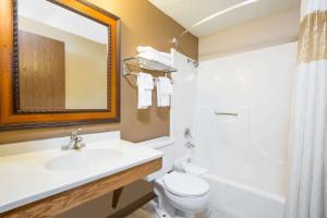 ein Badezimmer mit Waschbecken, Toilette und Spiegel in der Unterkunft Super 8 by Wyndham Sioux City/Morningside Area in Sioux City