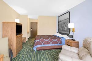 ein Hotelzimmer mit einem Bett und einem Sofa in der Unterkunft Boarders Inn & Suites by Cobblestone Hotels Waterloo Cedar Falls in Waterloo