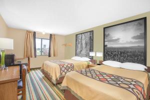 una habitación de hotel con 2 camas y un cuadro en la pared en Super 8 by Wyndham Mt Pleasant, en Mount Pleasant