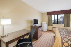 a hotel room with a bed and a desk with a computer at Super 8 by Wyndham Story City in Story City