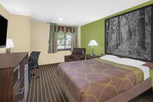 a hotel room with a bed and a flat screen tv at Super 8 by Wyndham Webster City IA in Webster City +17 photos