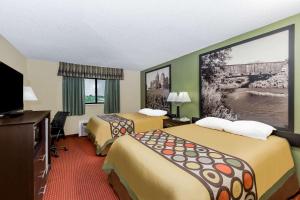 a hotel room with two beds and a flat screen tv at Western Inn & Suite Grinnell IA in Grinnell +39 photos