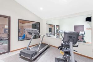 a gym with treadmills and a treadmill and mirrors at Super 8 by Wyndham Dodgeville in Dodgeville