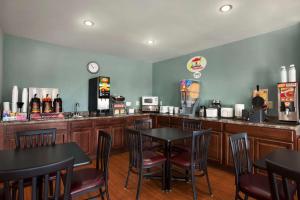 um bar com mesas e cadeiras num restaurante em Super 8 by Wyndham Council Bluffs IA Omaha NE Area em Council Bluffs