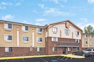 a large brick building with a car parked in a parking lot at Super 8 by Wyndham Baltimore/Essex Area in Essex