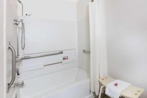 a white bathroom with a shower and a toilet at Super 8 by Wyndham Aberdeen MD in Aberdeen +24 photos