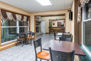 une salle à manger avec des tables et des chaises dans un restaurant dans l'établissement Super 8 by Wyndham Higginsville, à Higginsville