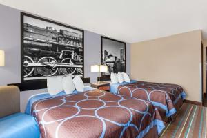 a hotel room with two beds and a picture of a train at Super 8 by Wyndham Havre De Grace Aberdeen Area in Havre de Grace