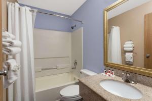 a bathroom with a sink and a toilet and a mirror at Super 8 by Wyndham Havre De Grace Aberdeen Area in Havre de Grace
