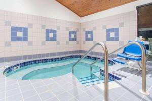 een zwembad met een hot tub in de badkamer bij Super 8 by Wyndham Dodgeville in Dodgeville