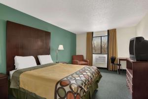 a hotel room with a bed and a flat screen tv at Quality Inn in Jackson