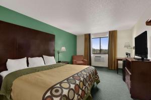 a hotel room with a bed and a flat screen tv at Quality Inn in Jackson