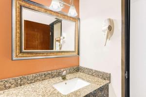 een badkamer met een wastafel en een spiegel bij Super 8 by Wyndham Hagerstown I-70 in Hagerstown +30 foto's