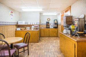 a restaurant with a table and chairs and a kitchen at Super 8 by Wyndham Nevada in Nevada