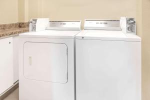 2 Waschmaschinen und ein Kühlschrank in einem Zimmer in der Unterkunft Super 8 by Wyndham East Moline in East Moline
