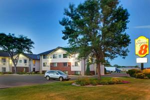 Un cartel de un hotel con un coche aparcado en un estacionamiento. en Super 8 by Wyndham Aberdeen East, en Aberdeen