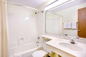 a white bathroom with a sink and a shower at Super 8 by Wyndham Aberdeen East in Aberdeen