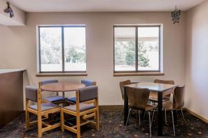 ein Wartezimmer mit zwei Tischen und Stühlen und zwei Fenstern in der Unterkunft Super 8 by Wyndham Madison in Madison