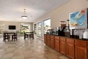 cocina grande y comedor con mesa en Super 8 by Wyndham Rapid City Rushmore Rd, en Rapid City