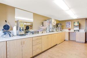 a kitchen with wooden cabinets and a counter top at Super 8 by Wyndham Mitchell in Mitchell