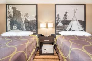 - 2 lits dans une chambre d'hôtel avec des photos sur les murs dans l'établissement Super 8 by Wyndham Miller, à Miller