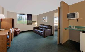 a hotel room with a couch and a microwave at Super 8 by Wyndham Spearfish in Spearfish