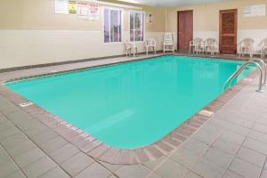 a pool in a hotel room with chairs around it at Super 8 by Wyndham O'Fallon MO/St. Louis Area in O'Fallon